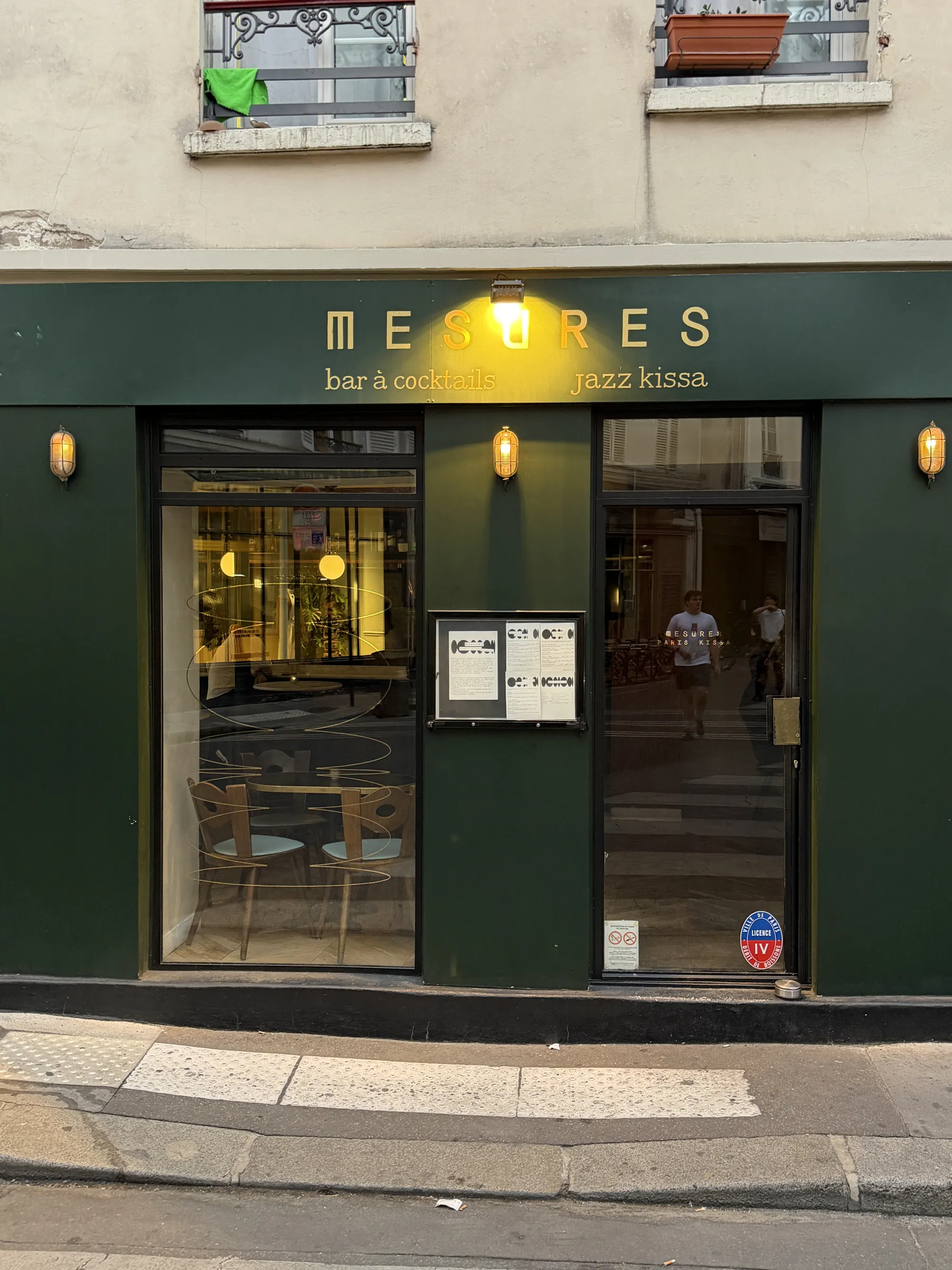 The dark green shopfront of Mesures in Paris, lettered bar à vin and jazz kissa