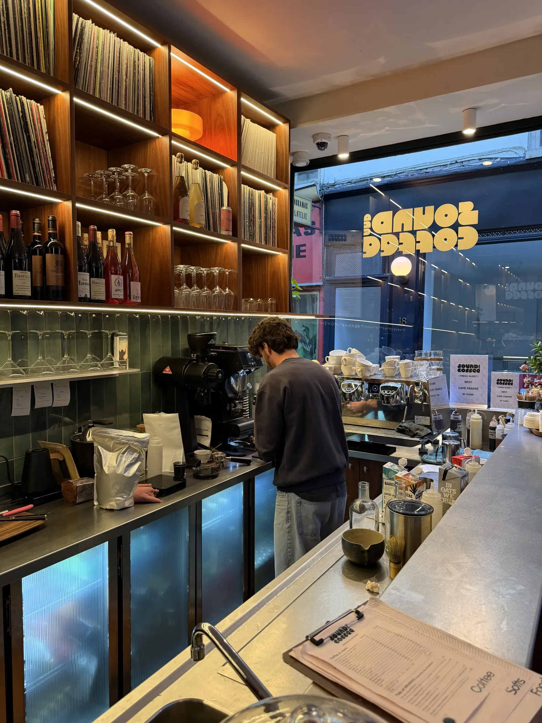 Coffee being made at Sound and Coffee, Paris, with records and wine along the back wall