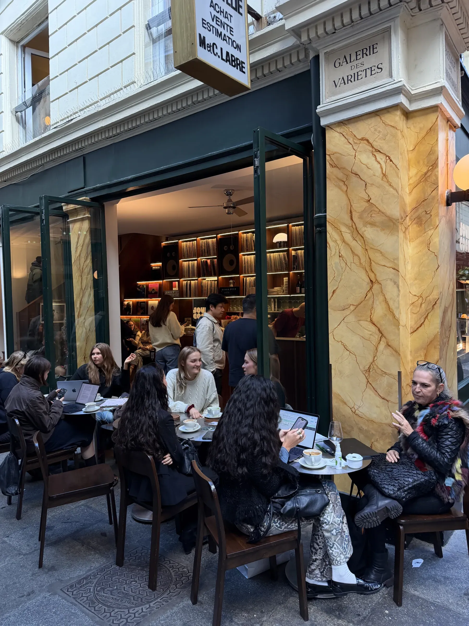People at the pavement tables outside Sound and Coffee in Passage des Panoramas, Paris